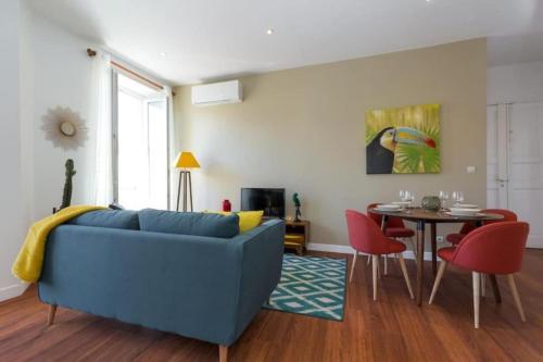 un salon avec un canapé bleu et une table dans l'établissement GIOFFREDO 55 - 2 beds w AC on Massena Square, à Nice