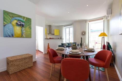 une salle à manger avec une table et des chaises rouges dans l'établissement GIOFFREDO 55 - 2 beds w AC on Massena Square, à Nice