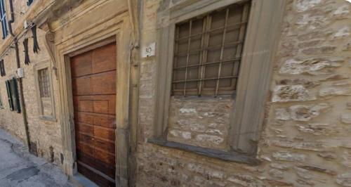 a building with a wooden door and a window at ViaReposati30 in Gubbio