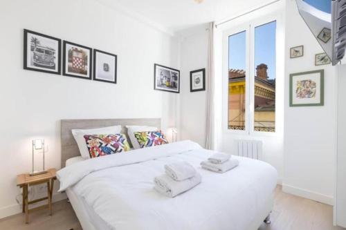 une chambre avec un lit blanc avec des serviettes dessus dans l'établissement MOULIN - Stunning 1 bedroom Apt on the Port, à Nice
