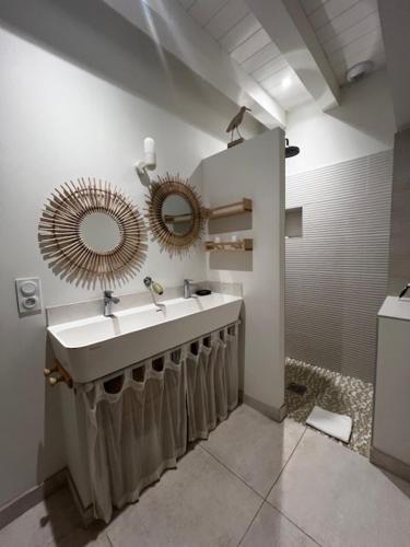 une salle de bain avec un lavabo et un miroir dans l'établissement La Landaise - Les Maisons Huraia, à Vielle-Saint-Girons