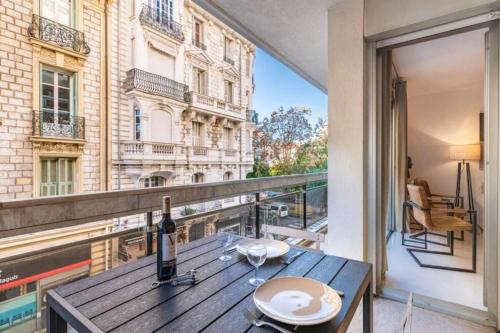 - une table avec une bouteille de vin sur le balcon dans l'établissement ROSSINI - Central and cosy with AC, à Nice