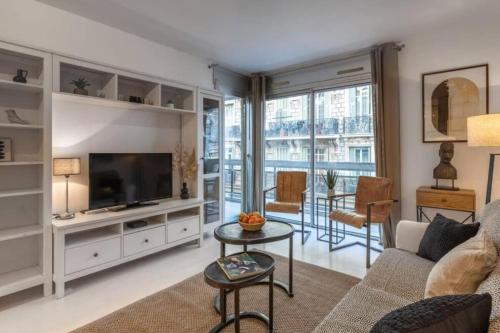 un salon avec un canapé et une télévision dans l'établissement ROSSINI - Central and cosy with AC, à Nice