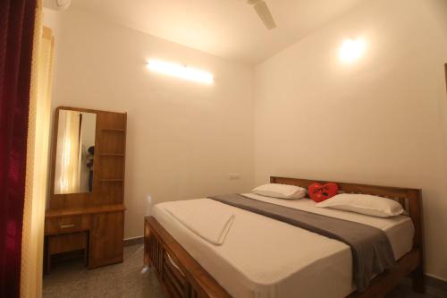 a bedroom with a large bed and a mirror at Periyar Homes Plantation Stay in Thekkady