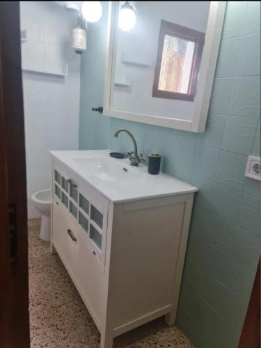 a bathroom with a sink and a mirror and a toilet at Casa Elviras in Alcossebre