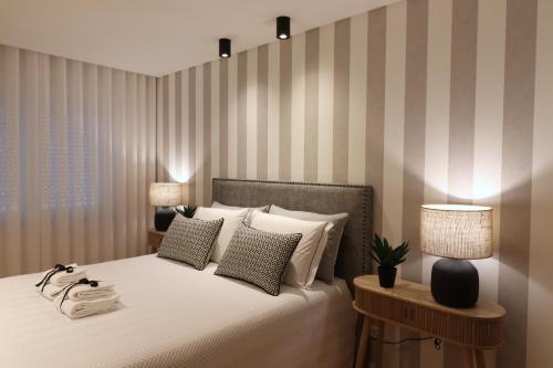a bedroom with a bed with two lamps and two tables at Casa "Patota" - Nazaré - Alojamento Local in Nazaré