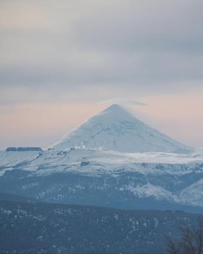 a mountain in the distance with snow on it at Álamos de los Andes - Andarlibre in San Martín de los Andes