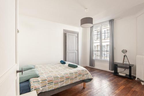 une chambre blanche avec un lit et une fenêtre dans l'établissement Appartement Ancien - 4 chambres - Centre ville Poitiers, à Poitiers