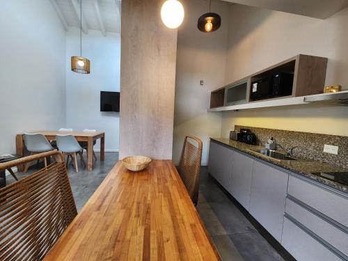 a kitchen with a wooden table and a dining room at Álamos de los Andes - Andarlibre in San Martín de los Andes