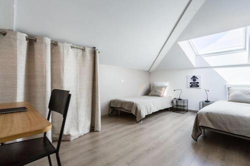 une chambre avec deux lits et un bureau et une fenêtre dans l'établissement La Bastide - Le Grenache - Le Syrah au Domaine Chateau Henri Bonnaud, au Tholonet