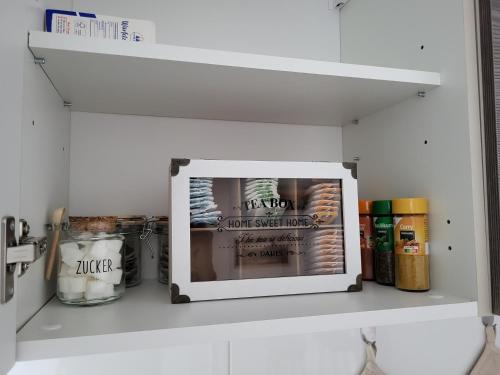 a kitchen shelf with a photo of a refrigerator at Charmante & Gemütliche Wohnung inkl Kaffee und Tee in Wuppertal