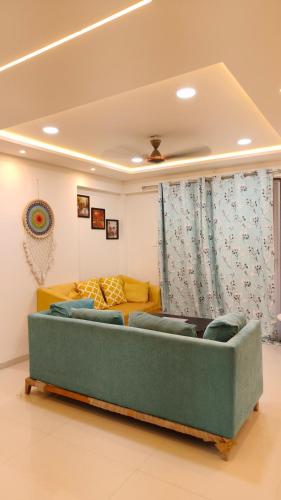 a living room with a couch and a yellow sofa at AeroNest - 3 BHK Apartment in Pune