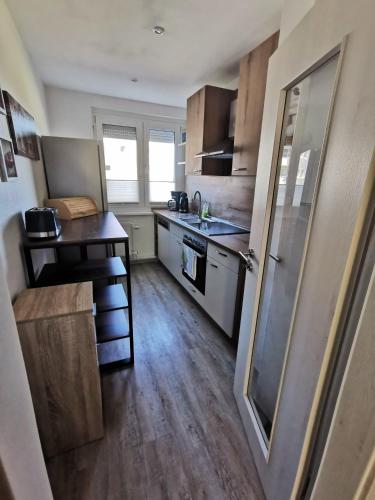 a small kitchen with a sink and a refrigerator at Moderne Ferienwohnung mit Seeblick und Balkon im EG in Mücheln