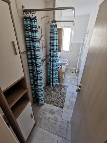 a bathroom with blue shower curtains and a sink at Moderne Ferienwohnung mit Seeblick und Balkon im EG in Mücheln
