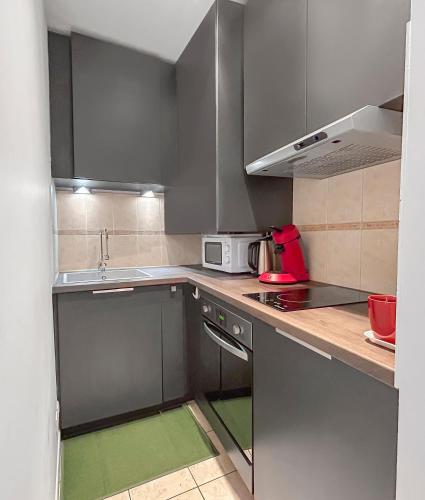 une cuisine avec des armoires en acier inoxydable et un évier dans l'établissement Nid douillet au coeur d'Uzès, à Uzès