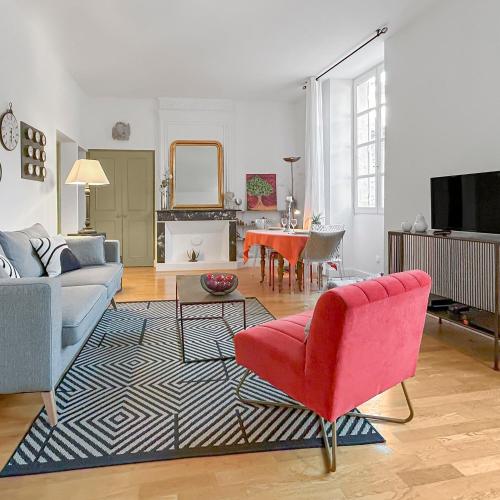 - un salon avec un canapé et un fauteuil rouge dans l'établissement Nid douillet au coeur d'Uzès, à Uzès