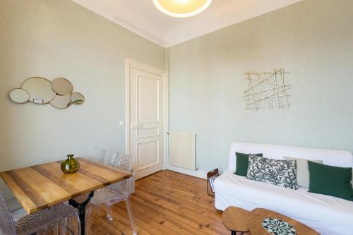 un salon avec une table et un canapé dans l'établissement Appartement Brise Marine - Welkeys, à Biarritz
