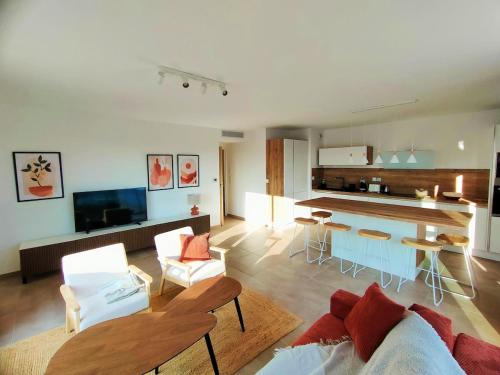 un salon avec un canapé et une table et une cuisine dans l'établissement MILLESIME 5303 : Vue magnifique, spacieux, sur le Port avec parking, à Marseillan