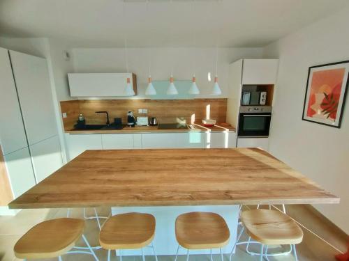 une cuisine avec une grande table et des chaises en bois dans l'établissement MILLESIME 5303 : Vue magnifique, spacieux, sur le Port avec parking, à Marseillan