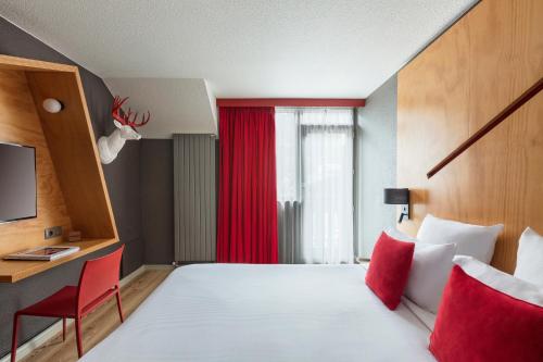 a hotel room with a large bed and a red window at Hôtel Les Aiglons Chamonix in Chamonix