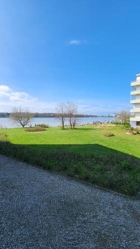 a grassy field next to a body of water at Steinwarder 1 - Haus "Seerose" ST1 034 Steinwarder 1 in Heiligenhafen