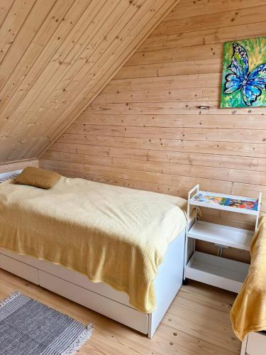 a bedroom with a bed in a wooden wall at Domki w brzozach in Brajniki