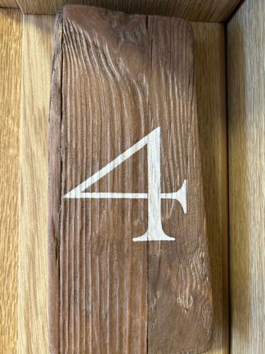a wooden sign with the letter k on it at Strandbude Borkum in Borkum