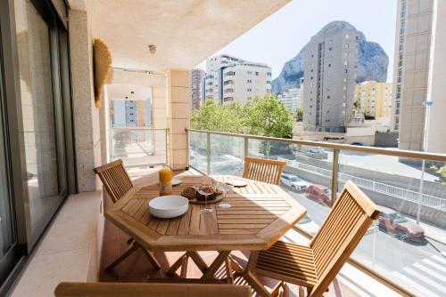 a table and chairs on a balcony with a view of a city at Apartamento en Calpe - Cerca del Club Náutico y playas in Calpe