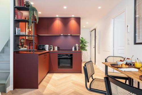 une cuisine avec des placards bruns et une table avec des chaises dans l'établissement HEROLD 60 - Cosy Apartment Suite w AC Downtown, à Nice