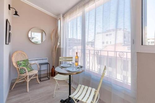 une salle à manger avec une table et des chaises et une fenêtre dans l'établissement LAMARTINE - Studio w terrace and AC Very central, à Nice