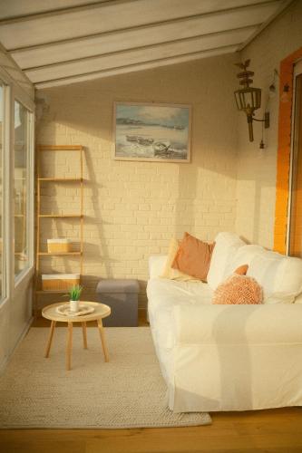 a living room with a white couch and a table at Le Chalet in Bouillon
