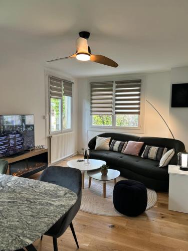Una sala de estar con un sofá negro y una mesa. en COEUR DE LOTOISE Votre havre de charme au cœur de Gramat, en Gramat