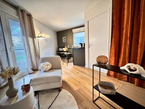 Una sala de estar con una silla y una mesa. en Le BraSeo, nice studio with parking in Rennes, en Rennes