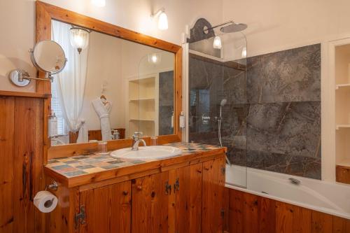 a bathroom with a sink and a large mirror at La Baronnie Hôtel & Spa - Teritoria in Saint-Martin-de-Ré