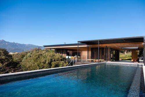 une maison avec une piscine devant dans l'établissement Casa Nera, à Pianottoli-Caldarello
