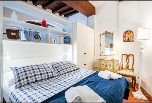 Un dormitorio con una cama azul y blanca y una silla en Apartment Magnoli&Ponte Vecchio, en Florencia