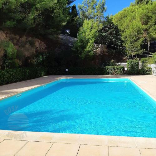 une piscine avec de l'eau bleue dans une cour dans l'établissement T2 terrasse vue panoramique, piscine, parking, wifi, 2 tv connectées, netflix, clim, ascenseur, barbecue, à Sète