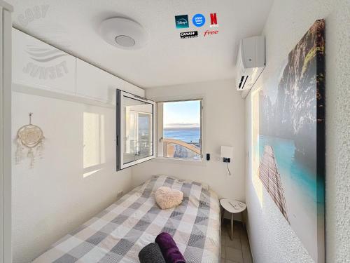 une petite pièce avec un lit et une fenêtre dans l'établissement T2 terrasse vue panoramique, piscine, parking, wifi, 2 tv connectées, netflix, clim, ascenseur, barbecue, à Sète