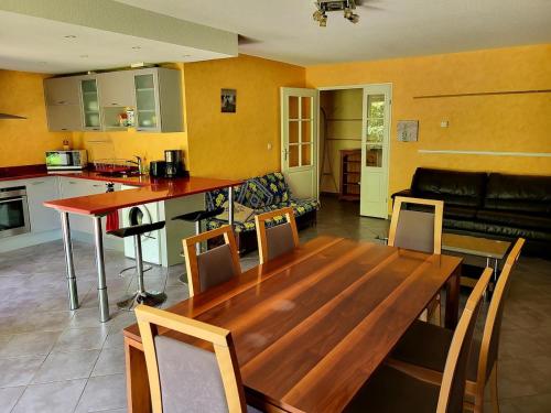 Il comprend un salon avec une table en bois et une cuisine. dans l'établissement T4 90 m2, Terrasse et jardin privé 100m2, à Toulouse