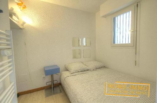 une petite chambre avec un lit et une fenêtre dans l'établissement Charmant 2 pièces dans résidence avec piscine, à Vallauris