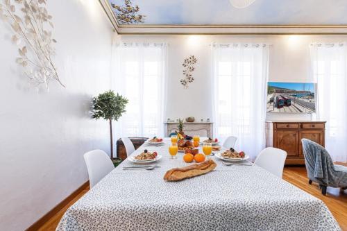 une salle à manger avec une table sur laquelle se trouve de la nourriture dans l'établissement RISSO - Comfortable 3 Bedrooms with balcony, à Nice