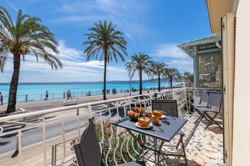 a table on a balcony with a view of the beach at PONCHETTE - Independent House Promenade Des Anglais in Nice