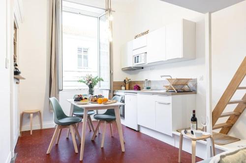 une cuisine avec des armoires blanches et une table et des chaises dans l'établissement PREFECTURE 15 - Old Town Duplex 2 doubles beds, à Nice
