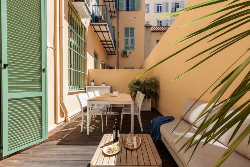 - un balcon avec une table et une bouteille de vin dans l'établissement GUBERNATIS - Beautiful Duplex with terrace, à Nice