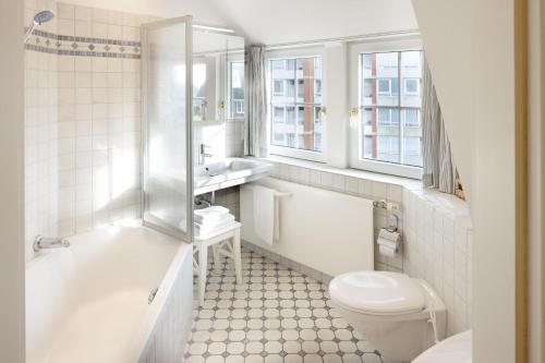 une salle de bains blanche avec toilettes et lavabo dans l'établissement Senenskiin, à List auf Sylt