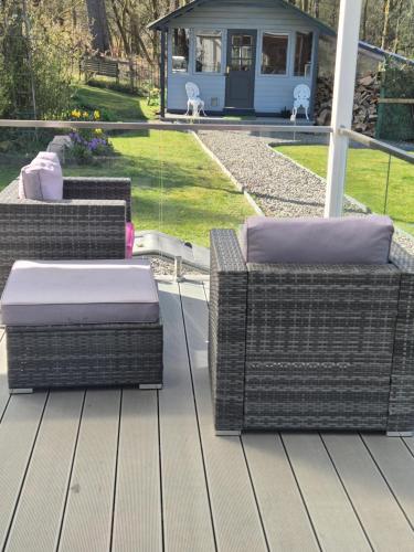 three wicker chairs and tables on a patio at Pinetree Cottage, dog friendly, Holiday let, Callander Invertrossachs in Callander