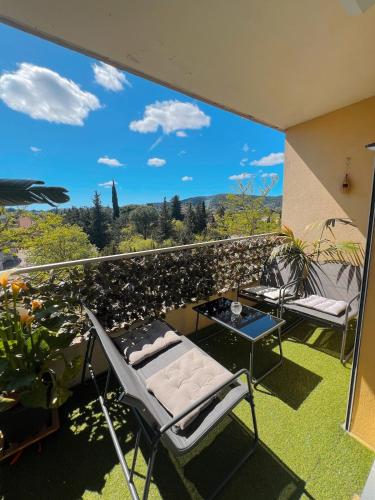 un balcon avec des chaises et une table et une vue dans l'établissement Charmant T3 avec clim et parking gratuit, à Draguignan