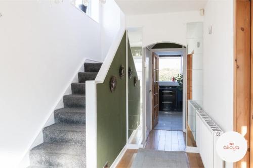 a staircase in a house with a green wall at Warm and Radiant 4Bed Home Near City - Airport in Baguley