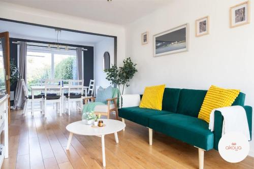 a living room with a green couch and a table at Warm and Radiant 4Bed Home Near City - Airport in Baguley