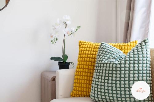 a room with two pillows and a vase with a plant at Warm and Radiant 4Bed Home Near City - Airport in Baguley